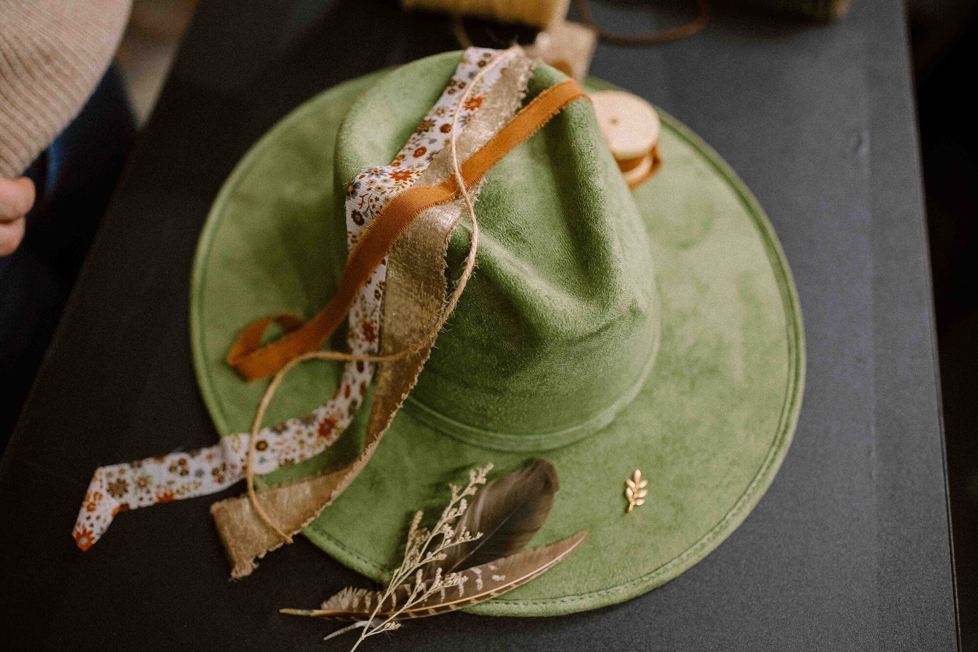 Charms, pins, and ribbons laid out for hat styling